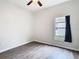 This cozy bedroom has wood-look floors, a ceiling fan and a bright window view at 6328 Desert Peace Ave, Land O Lakes, FL 34639