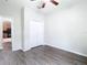 Bright bedroom with wood-look floors, a ceiling fan, and closet access at 6328 Desert Peace Ave, Land O Lakes, FL 34639