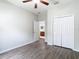 Bright bedroom with wood-look floors, a ceiling fan, closet, and ensuite bathroom access at 6328 Desert Peace Ave, Land O Lakes, FL 34639
