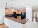 Open kitchen showcasing wood cabinets, modern appliances, breakfast bar, and tile flooring, perfect for entertaining at 6328 Desert Peace Ave, Land O Lakes, FL 34639