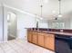 Bright and functional kitchen with wood cabinets, breakfast bar, tile flooring, and open access to the living areas at 6328 Desert Peace Ave, Land O Lakes, FL 34639