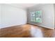 Inviting living room with hardwood floors, large window offering natural light, and neutral paint throughout at 6328 Desert Peace Ave, Land O Lakes, FL 34639