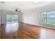 Bright living room with hardwood flooring, ceiling fan and sliding door to the outdoor patio at 6328 Desert Peace Ave, Land O Lakes, FL 34639
