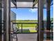 View of outdoor balcony with seating and scenic green space seen through sliding glass doors at 6500 Motor Enclave Way # 513, Tampa, FL 33610