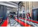 Showroom-style garage with a lift, two sports cars, and eye-catching black, white, and red flooring at 6500 Motor Enclave Way # 513, Tampa, FL 33610
