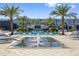 Resort-style pool area with palm trees, lounge chairs, and a central water fountain feature, under a bright blue sky at 6500 Motor Enclave Way # 513, Tampa, FL 33610