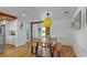 Bright dining room with a modern table, hardwood floors, a yellow pendant light, and entry to other rooms at 6780 14Th Way S, St Petersburg, FL 33705