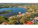 Aerial view of a lakeside home with mature trees and a screened-in pool at 7226 Bryce N Pt, Pinellas Park, FL 33782