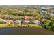 Aerial view showcasing houses with pools and lake access in a lush, green area at 7226 Bryce N Pt, Pinellas Park, FL 33782