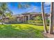 Landscaped front yard with mature trees, lush lawn, and covered entryway leading to this home at 7226 Bryce N Pt, Pinellas Park, FL 33782