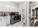 Functional laundry area equipped with modern washer and dryer, complete with storage and utility sink at 7226 Bryce N Pt, Pinellas Park, FL 33782