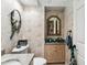 Stylish powder room with artistic wallpaper, decorative mirror, and neatly arranged vanity and toilet at 7226 Bryce N Pt, Pinellas Park, FL 33782
