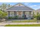 Charming gray home featuring a welcoming front porch with white railings and a black iron fence at 734 Newton S Ave, St Petersburg, FL 33701