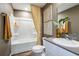 Well-lit bathroom with white tub/shower combo, decorative curtain, and framed wall art at 7647 Peace Lily Ave, Wesley Chapel, FL 33545