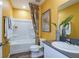 Bright bathroom with a tub, shower, toilet, and vanity with a plant, offering a clean and functional design at 7647 Peace Lily Ave, Wesley Chapel, FL 33545