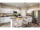 Modern kitchen with stainless steel appliances, gray countertops, and stylish barstool seating at 7647 Peace Lily Ave, Wesley Chapel, FL 33545
