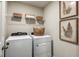 Convenient laundry room with a washer, dryer, storage shelves, and tasteful wall art at 7647 Peace Lily Ave, Wesley Chapel, FL 33545