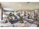 Open-concept living room with contemporary decor, hardwood floors, and ample seating at 7647 Peace Lily Ave, Wesley Chapel, FL 33545