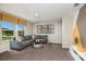 Cozy living room featuring a gray sectional, modern decor, and a bright window with natural light at 7647 Peace Lily Ave, Wesley Chapel, FL 33545