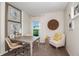 Bright office featuring a desk, chair, artwork, and a comfortable armchair with natural light from the window at 7647 Peace Lily Ave, Wesley Chapel, FL 33545