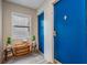 Bright entryway features a small window, bench with small stools, and a vibrant blue door that leads into the unit at 841 4Th N Ave # 57, St Petersburg, FL 33701