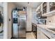 Galley kitchen featuring stainless steel refrigerator and range, white cabinetry, and stone countertops at 841 4Th N Ave # 57, St Petersburg, FL 33701