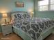 Comfortable bedroom with a queen-sized bed, nightstands, and a beach-themed painting at 8567 W Gulf Blvd # 17N, Treasure Island, FL 33706