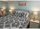 Comfortable bedroom featuring a queen-sized bed, nightstands, and a beach-themed painting at 8567 W Gulf Blvd # 17N, Treasure Island, FL 33706