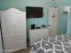 Comfortable bedroom with a television, white dresser and armoire, and pleasing decor creating a cozy space at 8567 W Gulf Blvd # 17N, Treasure Island, FL 33706