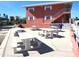 A red building with exterior picnic tables, with an outdoor community space perfect for gatherings at 8567 W Gulf Blvd # 17N, Treasure Island, FL 33706