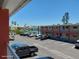 View of the building and ample parking available, with a glimpse of the bay, tall trees and other buildings at 8567 W Gulf Blvd # 17N, Treasure Island, FL 33706