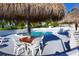 Refreshing pool area providing a serene setting with ample seating, tiki umbrellas, and lush landscaping for relaxation at 8567 W Gulf Blvd # 17N, Treasure Island, FL 33706