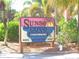 Eye-catching community sign amid lush landscaping, creating an inviting entrance to the Sunset Cove Condominiums at 8567 W Gulf Blvd # 17N, Treasure Island, FL 33706