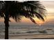 Ocean sunset view with a palm tree silhouette in the foreground at 8567 W Gulf Blvd # 17N, Treasure Island, FL 33706