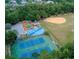 Aerial view of community park featuring tennis courts, a playground, a baseball field, and green spaces at 8713 Hampden Dr, Tampa, FL 33626