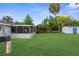 Expansive backyard features a lush lawn, mature trees, and a storage shed at 9307 N 27Th St, Tampa, FL 33612