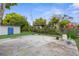 Wide backyard with a concrete patio, storage shed, mature trees, and utility connections at 9307 N 27Th St, Tampa, FL 33612