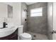 Modern bathroom featuring tiled walk-in shower with a black shower head and a modern sink at 9307 N 27Th St, Tampa, FL 33612