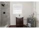Bathroom featuring tiled walk-in shower, window, and sink with storage at 9307 N 27Th St, Tampa, FL 33612
