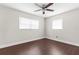 Bright bedroom featuring modern ceiling fan, crisp white walls, and attractive dark-toned wood flooring at 9307 N 27Th St, Tampa, FL 33612