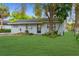 Charming single-story home featuring a lush green lawn and mature trees in a tranquil setting at 9307 N 27Th St, Tampa, FL 33612