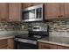The kitchen features stainless steel appliances including a smooth top range and microwave at 9307 N 27Th St, Tampa, FL 33612