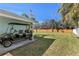 Backyard and side parking area with golf cart near the lush green lawn and fence at 1003 39Th Ne Ave, St Petersburg, FL 33703