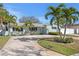 Charming single-story home featuring a well-manicured lawn, palm trees, and a spacious driveway at 1003 39Th Ne Ave, St Petersburg, FL 33703