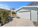 View of the garage, pergola, and garden area with flowers and plants at 1003 39Th Ne Ave, St Petersburg, FL 33703