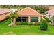 A cozy home with a tiled roof, a screened-in patio, and lush green landscaping at 10213 Saint Francis Ter, Palmetto, FL 34221