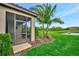A screened-in back porch overlooking a lush green lawn and serene pond at 10213 Saint Francis Ter, Palmetto, FL 34221