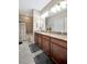 Bathroom featuring double vanity with granite countertops and tiled shower-tub combo at 10213 Saint Francis Ter, Palmetto, FL 34221
