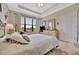 This spacious bedroom features a tray ceiling, large window, and a dresser with a vanity mirror at 10213 Saint Francis Ter, Palmetto, FL 34221