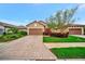 Charming single-story home featuring a brick driveway, a well-manicured lawn, and colorful landscaping at 10213 Saint Francis Ter, Palmetto, FL 34221